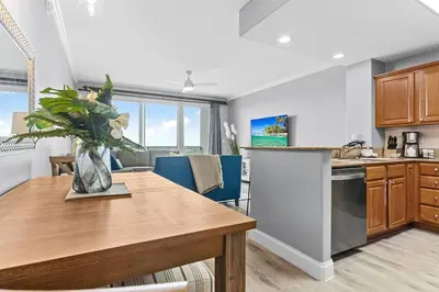 a kitchen and dining room with a wooden table at Scenic View Condo Near Disney in Orlando