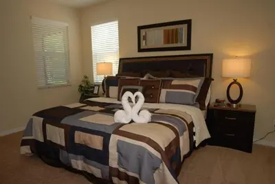 a bedroom with a bed with two towels on it at Beautiful Renovated 6 Bed Pool Home home in Kissimmee