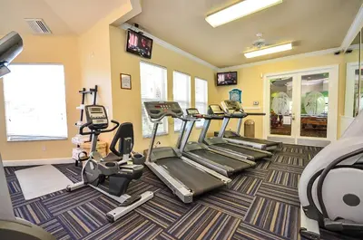 a fitness room with treadmills and elliptical machines at 2301 Butterfly Palm Way 101 in Kissimmee