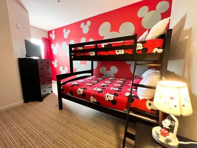 a bedroom with a bunk bed with mickey mouse wallpaper at Pet-Friendly 3BR Condo w Pool in Orlando