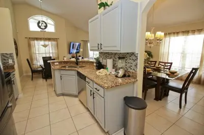 a kitchen with a sink and a dining room with a table at Gorgeous 4 Bed Home In Gated Community! villa in Kissimmee