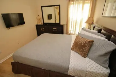 a bedroom with a bed with a mirror and a television at Gorgeous 4 Bed Home In Gated Community! villa in Kissimmee