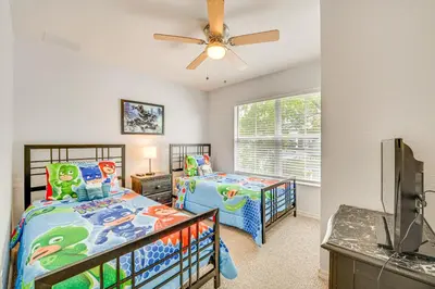 a bedroom with two beds and a ceiling fan at 11 Mi to Disney Venetian Bay Villages Townhome! in Kissimmee