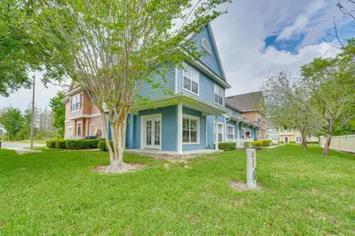 a blue house with a tree in the yard at 11 Mi to Disney Venetian Bay Villages Townhome! in Kissimmee