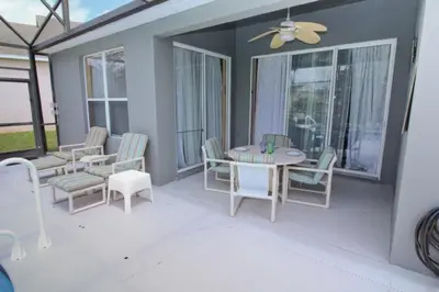 a screened in porch with a table and chairs at Luxury Villa With Private Pool And Great Game Room villa in Kissimmee