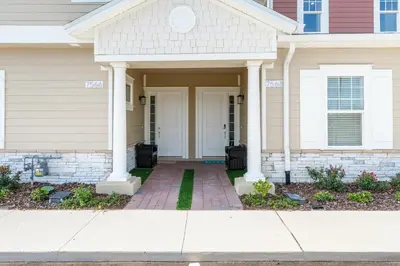 a house with a white door and a brick sidewalk at Comfortable home w 3 En-suites! SMV157 in Orlando