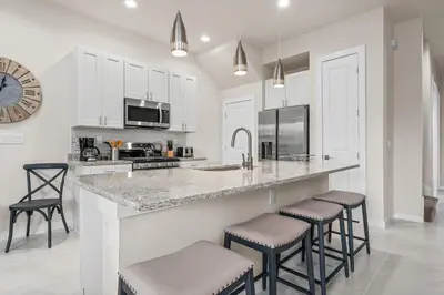 a kitchen with a large counter with stools in it at Comfortable home w 3 En-suites! SMV157 in Orlando