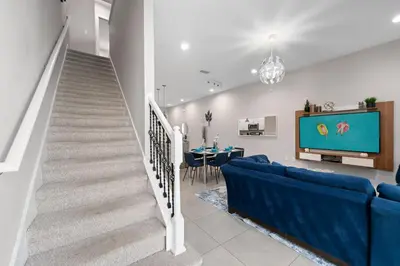 a living room with a blue couch and a tv at 4 Bedrooms 3 En-Suites, 5 Min to Disney SMV158 in Orlando