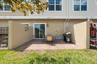 a patio with chairs and a grill in front of a house at 4 Bedrooms 3 En-Suites, 5 Min to Disney SMV158 in Orlando