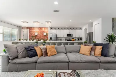 a living room with a gray couch with pillows at UNIQUE MASTERPIECE15 Suites Sleeps 30 SON101 in Kissimmee