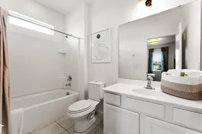 a white bathroom with a toilet and a sink at UNIQUE MASTERPIECE15 Suites Sleeps 30 SON101 in Kissimmee
