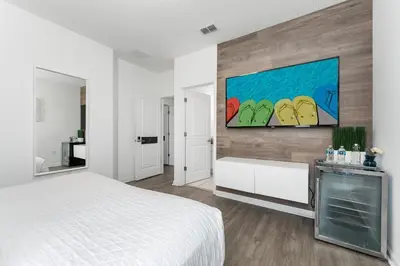 a bedroom with a bed and a painting on the wall at UNIQUE MASTERPIECE15 Suites Sleeps 30 SON101 in Kissimmee