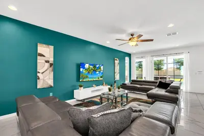a living room with a couch and a blue wall at Luxury Home at Sonoma 9 En-suites SON102 in Kissimmee