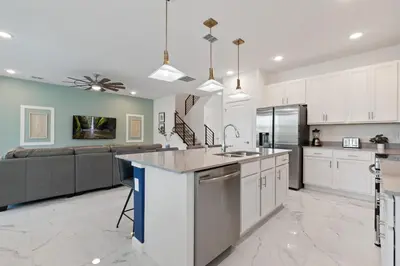 a large kitchen with white cabinets and a kitchen island at Stunning Modern Home VPR102 in Kissimmee