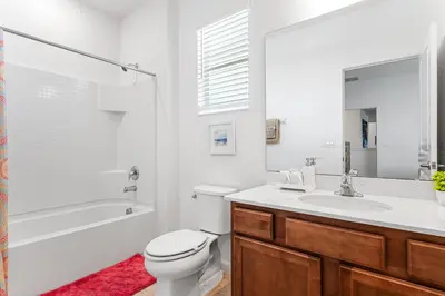 a white bathroom with a toilet and a sink at Lakeview Home Sleeps 25 VPR103 in Kissimmee