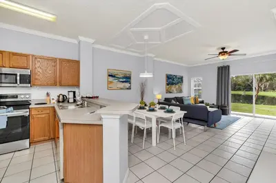 a kitchen and living room with a table and chairs at A Peaceful Orlando Escape, nature, comfort & Disney Nearby EMI101 in Kissimmee