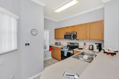 a kitchen with wooden cabinets and a counter top at A Peaceful Orlando Escape, nature, comfort & Disney Nearby EMI101 in Kissimmee