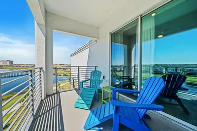 two blue chairs on a balcony with a view of the ocean at 3141 Paradox Circle 406 in Kissimmee