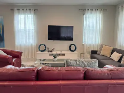 a living room with a red couch and a flat screen tv at 7491 Oasis at Reunion sleeps 12 in Orlando