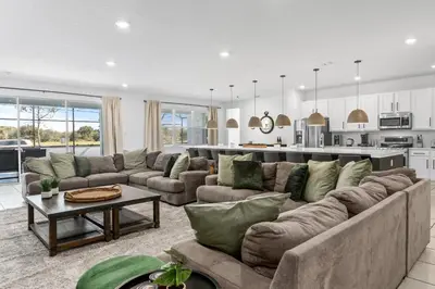 a living room with a large couch and a kitchen at Unique Masterpiece 15 En-suites VPR104 in Kissimmee