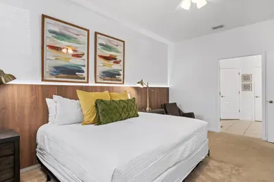 a bedroom with a large white bed and paintings on the wall at Unique Masterpiece 15 En-suites VPR104 in Kissimmee