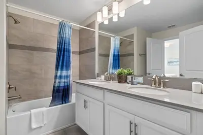 a bathroom with two sinks and a tub and a mirror at Comfy Townhome 8 Min to Disney STL120 in Kissimmee