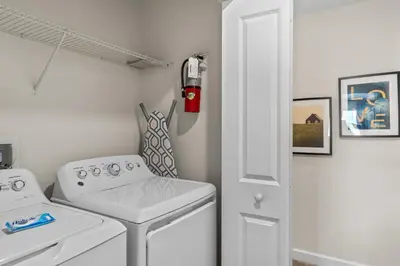 a small laundry room with a washer and dryer at Comfy Townhome 8 Min to Disney STL120 in Kissimmee