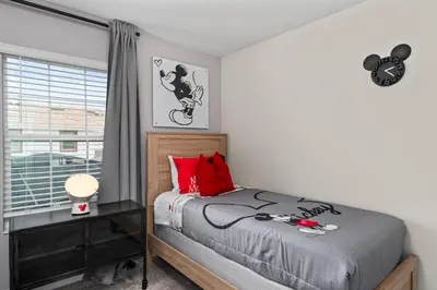 a bedroom with a bed with red pillows and a window at Comfy Townhome 8 Min to Disney STL120 in Kissimmee