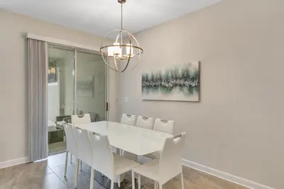 a dining room with a white table and white chairs at Private Pool 8 Min to Disney STL121 in Kissimmee