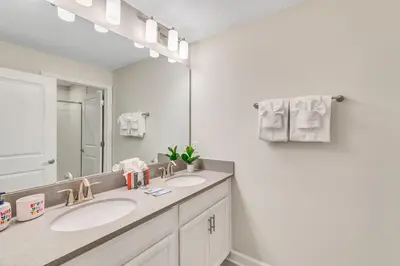 a bathroom with two sinks and a large mirror at Private Pool 8 Min to Disney STL121 in Kissimmee