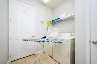 a laundry room with a table and a washer and dryer at Epic Universe Premium Lake View Condo, Vista Cay - 1002 in Orlando