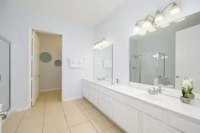 a white bathroom with two sinks and a large mirror at Beautiful Lakeview Vacation Condo, Vista Cay 1016 in Orlando