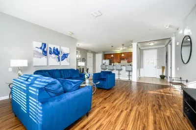 a living room with blue couches and a dining room at Epic Universe Family Fun Vista Cay Lakeview Condo - 1021 in Orlando
