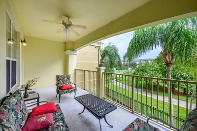 a balcony with a couch and a table and a fan at Epic Universe New Beautiful Lakeview Condo Near The Parks - 1026 in Orlando