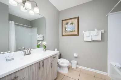 a bathroom with a sink and a toilet and a mirror at Stunning Vacation Condo - Vista Cay Resort - 2008 in Orlando