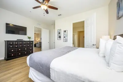 a bedroom with a white bed and a ceiling fan at Epic Universe Penthouse Vacation Condo, Near The Parks - 2014 in Orlando
