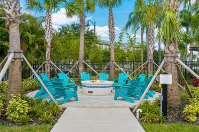 a group of blue chairs on a patio with palm trees at Beautiful Deluxe Condo, Vista Cay - 3015 in Orlando
