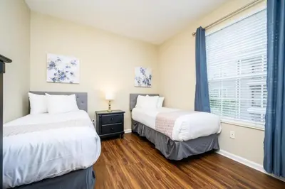 two beds in a room with a window at Beautiful Deluxe Condo, Vista Cay - 3023 in Orlando