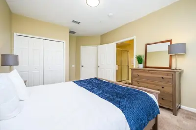 a bedroom with a bed and a dresser and a mirror at New Modern Townhome, Near The Parks - 4030 in Orlando