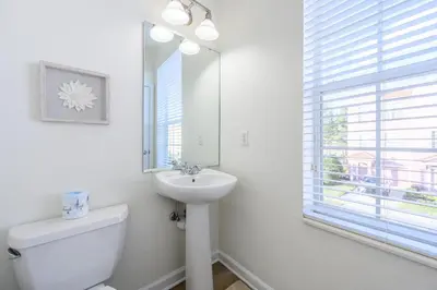 a bathroom with a sink and a toilet and a mirror at New Listing, Beautiful Townhome, Vista Cay - 4014 in Orlando