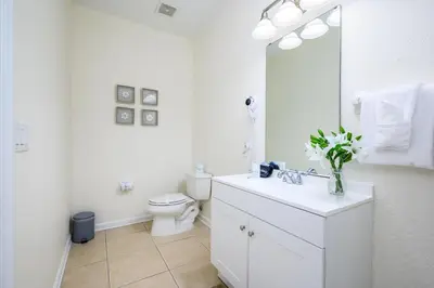 a white bathroom with a toilet and a sink at New Listing, Beautiful Townhome, Vista Cay - 4014 in Orlando