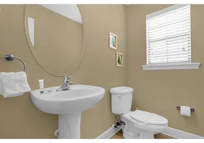 a bathroom with a sink and a mirror and a toilet at Summer Days Fun - Renovated TownHome by Disney! in Orlando