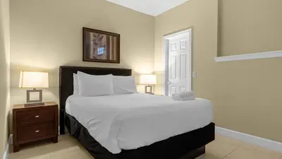 a bedroom with a large bed and two lamps at Book Your Summer Escape - TownHome by Disney! in Orlando