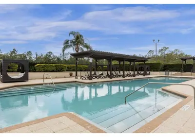 a large swimming pool with a gazebo at Sunny Summer in Orlando - TownHome by Disney! in Orlando