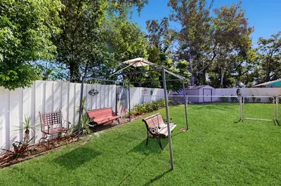two chairs and an umbrella in a yard at Pool Access! Dog-Friendly Retreat 16 Mi to Orlando in Orlando
