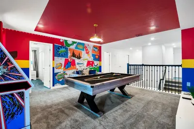 a room with a pool table and a colorful wall at Magical Mickey Home 8 minutes from Disney STL109 in Kissimmee