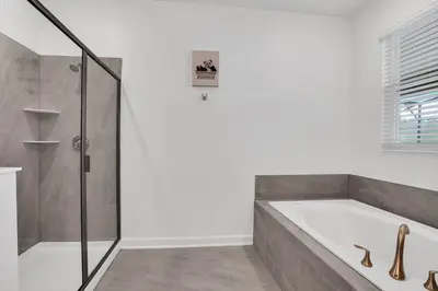 a bathroom with a bath tub and a shower at Magical Mickey Home 8 minutes from Disney STL109 in Kissimmee
