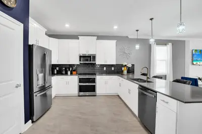 a kitchen with white cabinets and stainless steel appliances at Magical Mickey Home 8 minutes from Disney STL109 in Kissimmee