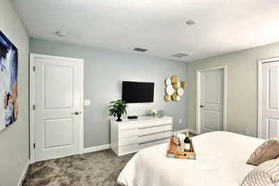 a bedroom with a bed and a tv on a wall at The Windermere - Pool Lazy River & Waterslides in Kissimmee