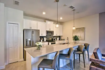 a kitchen with a large island with chairs and a counter at The Windermere - Pool Lazy River & Waterslides in Kissimmee